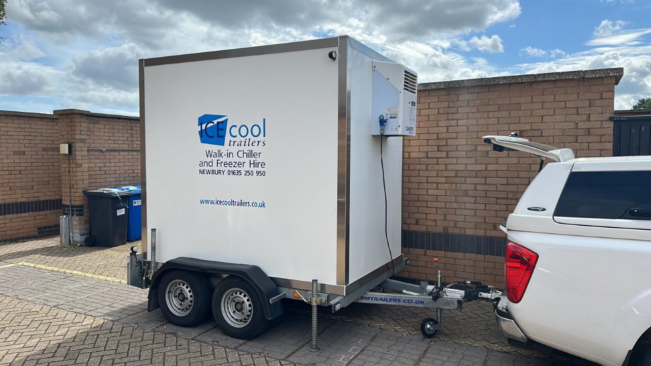 a freezer trailer attached to the backside of a pickup truck