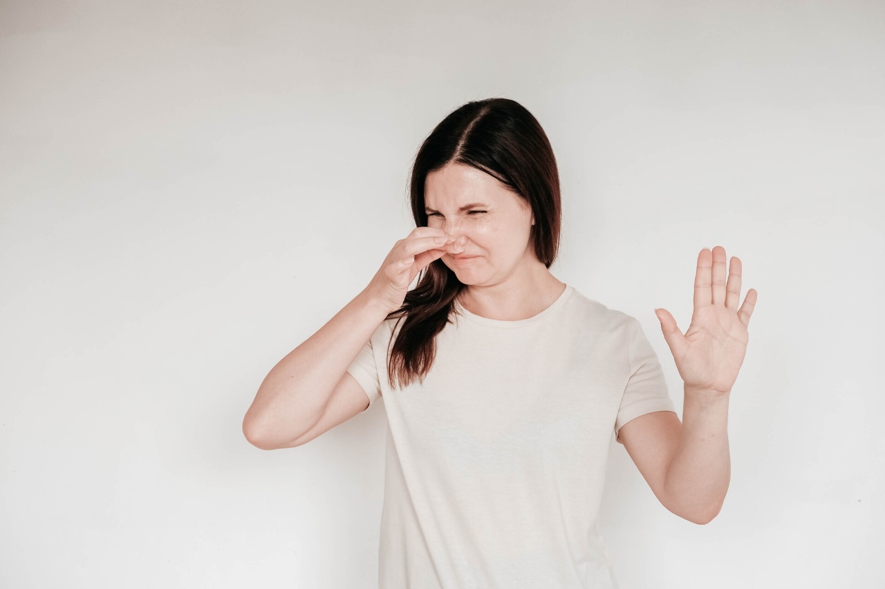 Woman dressed in casual white t shirt grimacing with disgust
